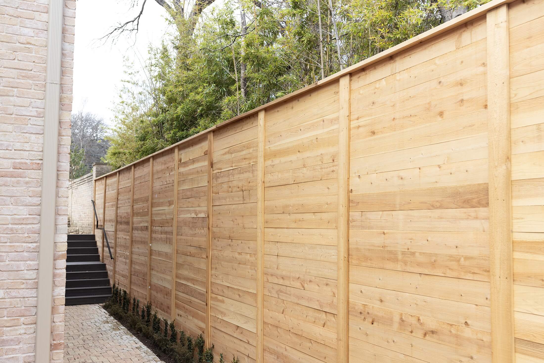 Newly built Colorbond fence with exposed timber posts on residential property.
