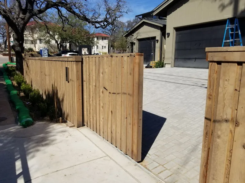 Newly built timber paling fence with exposed posts and capping on residential property.