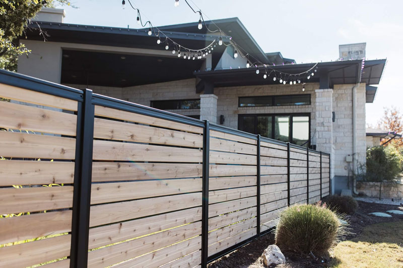 Newly built Colorbond fence with exposed timber posts on residential property.