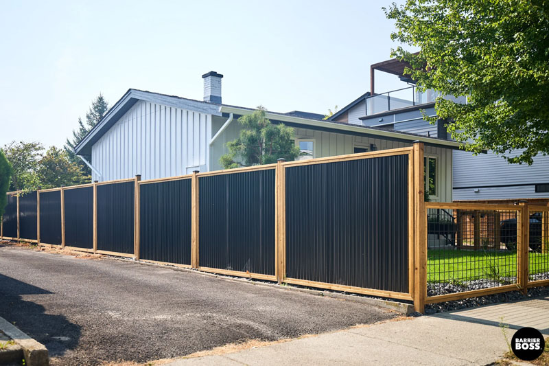 Newly built Colorbond fence with exposed timber posts on residential property.