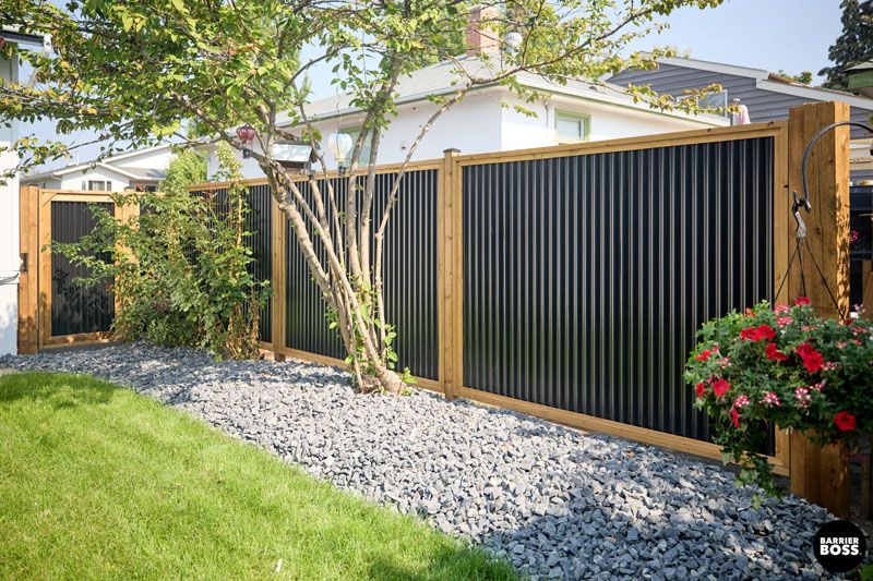 Newly built Colorbond fence with exposed timber posts on residential property.