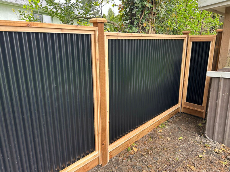 Newly built Colorbond fence with exposed timber posts on residential property.