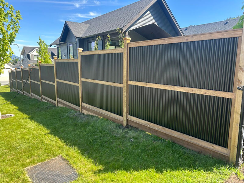 Newly built Colorbond fence with exposed timber posts on residential property.