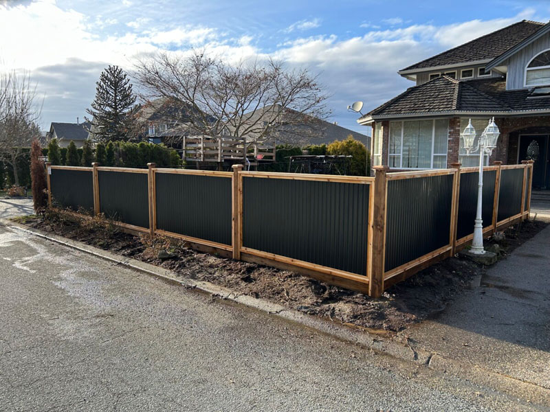 Newly built Colorbond fence with exposed timber posts on residential property.