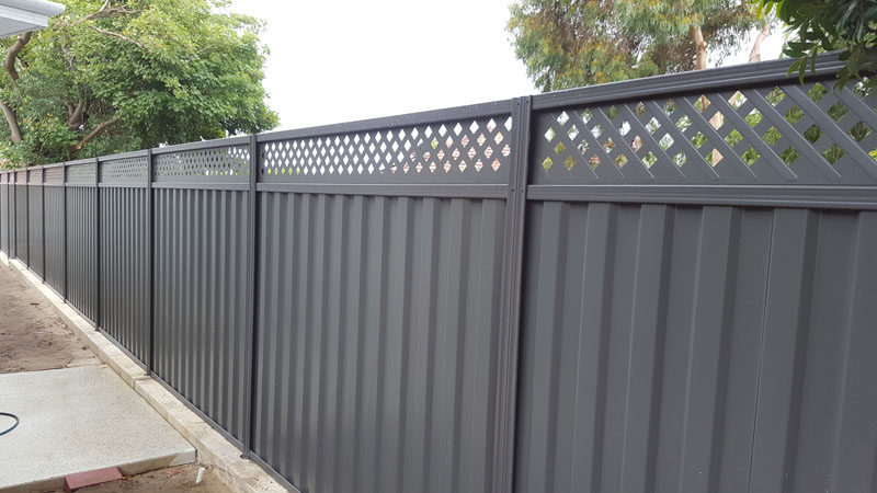Newly built Colorbond fence with exposed timber posts on residential property.