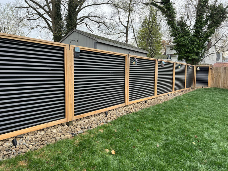 Newly built Colorbond fence with exposed timber posts on residential property.