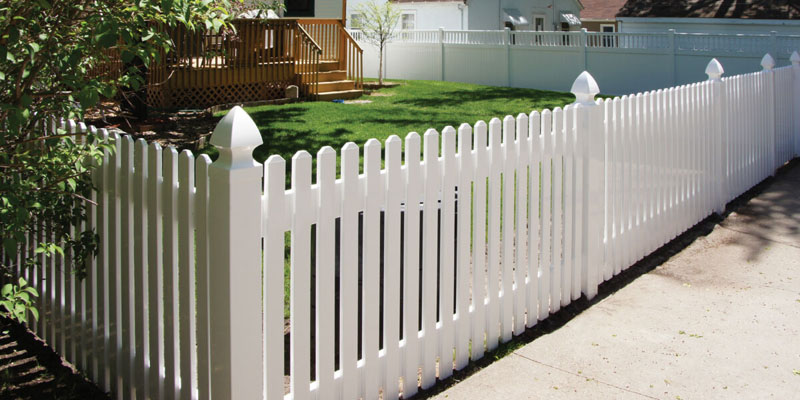Newly built PVC picket fence on residential property.