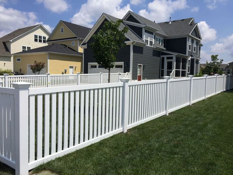 Newly built PVC picket fence on residential property.