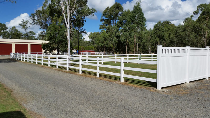 Newly built PVC post and rail fence on rural property.