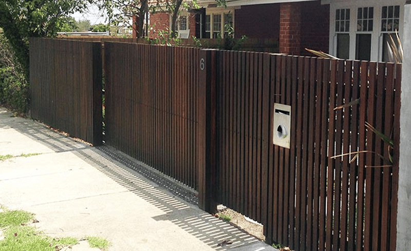 Newly built Colorbond fence with exposed timber posts on residential property.