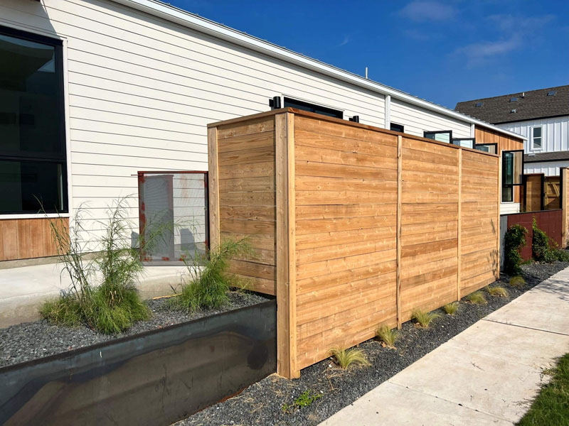 Timber paling fence with exposed posts and capping on residential property.